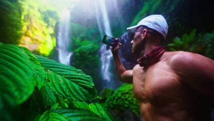 Wall Mural - Travel people enjoy famous destination Bali waterfall Sekumpul the highest and most beautiful waterfall in tropical rainforest Bali, Indonesia 4K