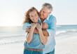 © Kay Abrahams/peopleimages.com - Senior, couple and portrait hug by the ocean with happiness and love on holiday in the outdoor. Mature, man and woman at the beach hugging on vacation with smile for travel together with sunshine.