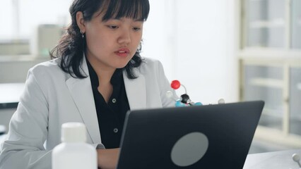 Poster - Female researcher looking at a molecular model. science student.