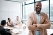 © Micah C/peopleimages.com - Business, black man and smile in portrait with arms crossed, leadership and meeting with group for corporate project. Team leader, management and confidence with male person in conference room