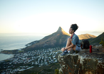 Woman, mountain and sitting with view of cityscape outdoor for exercise in Cape Town. Female hiking, cliff and South Africa for adventure in nature in the morning for wellness on the weekend.