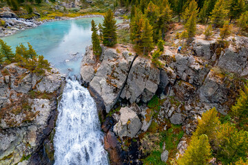 Wall Mural - Tourists group hike turquoise Kuyguk waterfall and Kuiguk lake in Altai mountains, Siberia Russia. Aerial top view