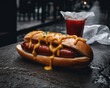 Frischer Hotdog mit Käsesoße im Brötchen in einer Seitenstraße, generative AI