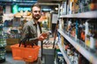 A man takes alcoholic drinks from the supermarket shelf. Shopping for alcohol in the store