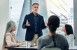 © Siphosethu Fanti/peopleimages.com - Businessman, coaching and meeting in seminar for strategy, planning or team discussion at office. Man CEO, mentor or coach training staff in teamwork, project plan or ideas in conference at workplace