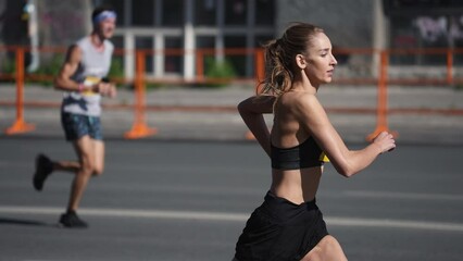 Wall Mural - Female jogger run marathon. Thin girl work out. Woman runner jog long distance. Finish line road. Sportswoman overtake man. Sporty athlete train. Fast sprint champion. Fit sport body. Active city life