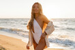 © Svetlana Sokolova - Seductive  blond woman in sexy swimwear posing on the beach in sunset light. Prtfect wavy hairs, tan skim body. Summer tropical mood.