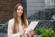 © Evgenia - business woman with a tablet in her hands on the background of an office building