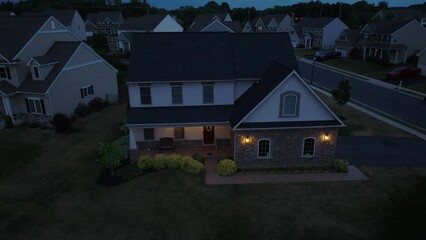 Wall Mural - Exterior view of American home at night. Aerial establishing orbit shot at dusk.