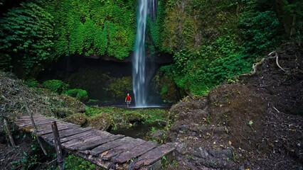 Wall Mural - Travel people explore beautiful Bali destination waterfall Pucak Manik hidden in tropical rainforest jungle on nature background 4K