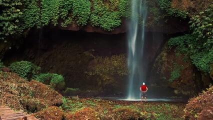 Wall Mural - Travel people explore beautiful Bali destination waterfall Pucak Manik hidden in tropical rainforest jungle on nature background 4K