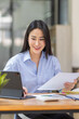 © David - Asian Business woman using calculator and laptop for doing math finance on an office desk, tax, report, accounting, statistics, and analytical research concept