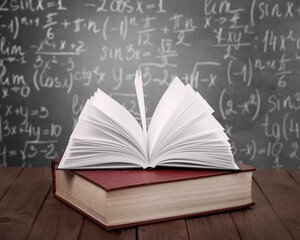 Canvas Print - Math geometry formulas and books on board background