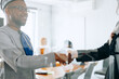© jaimelafrickmartial  - close up handshake of black and one white partner, two CEOs handshake partnership for business deal or financial cooperation concept.