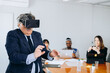 © jaimelafrickmartial  - Adult businessman showing young multi ethnic people in his company how to use VR glasses.