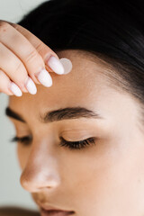 young woman using acne patches for treatment of pimple and rosacea close-up. facial rejuvenation cle