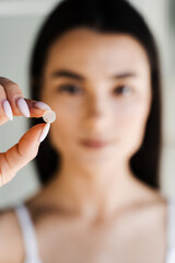 girl with acne round patch in hand close-up. using acne patches for treatment of pimple and rosacea 