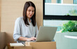 © Prot - Happy young Asian woman entrepreneur, Smile for sales success after checking order from online shopping store in a laptop at home office, Concept of merchant business online and eCommerce