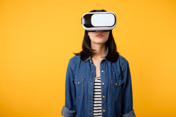 Poster - Young asian woman get experienced wearing virtual reality headset game entertainment isolated on yellow background. Winner of cyber future video game concept.