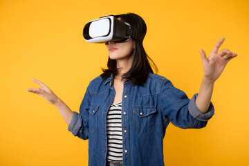 Poster - Young asian woman get experienced wearing virtual reality headset game entertainment isolated on yellow background. Winner of cyber future video game concept.