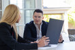 © SlavaStock - Blonde realtor presents advantages of new modern house to potential buyer. Young businessman interested in building investment