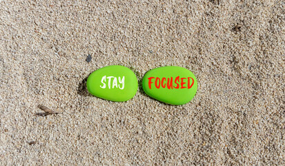 Stay focused symbol. Concept words Stay focused on beautiful green stone on a beautiful sand sea beach background. Business, support, motivation, psychological and stay focused concept. Copy space.