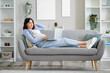 © Pixel-Shot - Young pregnant woman working with laptop on sofa at home
