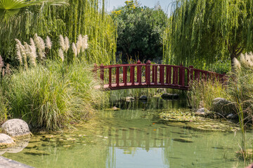 Poster - old wooden arch bridge in japanese zen garden