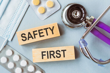 SAFETY FIRST text on a wooden blocks on a table next to a stethoscope