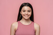 Portrait of cute, beautiful teenage girl in pink top looking at camera, isolated on pink background