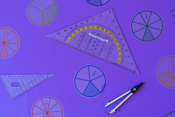 Wall Mural - Fractions, rulers on violet background. Set of supplies for mathematics and for school. Back to school, fun education concept. Geometry background	