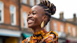 © wetzkaz - young adult african american or african black dark skinned woman with a smile and an updo wearing traditional colorful clothing in a european fictional town