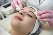 © RomanR - beautician applies or removes moisturizer from a client's face