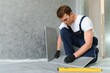 © Serhii - A male construction worker installs a large ceramic tile