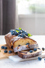 Wall Mural - fresh blueberry loaf of bread muffin cake with mint closeup on a table