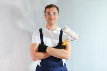 Wall Mural - Young worker painting wall in room