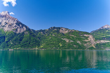  View of Lake Uri with beautiful mountain panorama and village Bauen on a sunny spring day. Photo taken May 22nd, 2023, Sisikon, Switzerland.