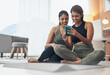 © Felix/peopleimages.com - Exercise, phone and women together at home with internet connection and social media. Indian sisters or female friends in lounge with smartphone for online class, chat or fitness workout with partner
