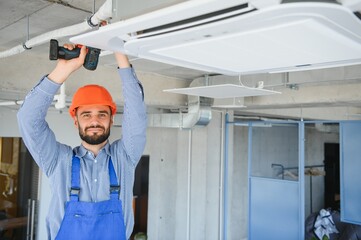 Wall Mural - technician service checking and repairing air conditioner indoors