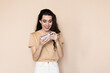 © F8  \ Suport Ukraine - Happy attractive woman joying win in video game on smartphone, isolated over beige background