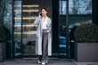 © Petro - Business woman talking on the phone outside office bulding