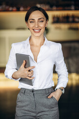 Canvas Print - Business woman holding tablet in a cafe