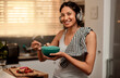 Headphones, eating breakfast and portrait of woman in kitchen with strawberry. Face headphone, food and happy female person with healthy fruit while listening to audio music, sound or radio podcast.