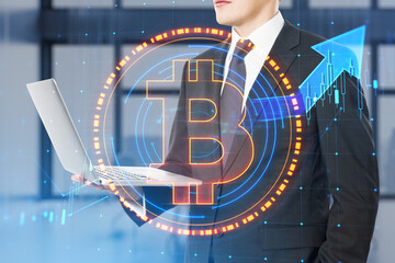Poster - Close up of businessman hand using laptop with glowing round bitcoin sign and forex chart hologram on blurry office interior background. Cryptocurrency and blockchain concept. Double exposure.