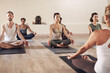 Yoga, meditation and class group in a wellness and health practice to relax with zen and peace. Female people, spiritual and holistic exercise with calm lotus pose with body balance on a gym mat
