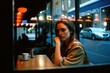 © Marcela Ruty Romero - Thoughtful young Caucasian woman drinking coffee at a bar, seen through a window with street reflections and neon lights. Generative AI