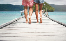 Couple, Feet And Ocean Pier On A Island On Vacation With Walking Freedom By Sea. Travel, Tropical Beach And Deck Walk Of A Man Back And Woman Together With Love In Summer On A Holiday Outdoor In Sun