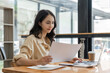 © Natee Meepian - businesswoman using calculator and laptop to calculate company financial result On wooden table in office and business background, tax, accounting, statistics and analytical research
