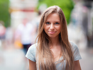 portrait of young smiling attractive caucasian woman in jeans jacket in the park at summer