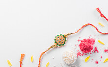 Raksha Bandhan, Indian Festival With Beautiful Rakhi And Rice Grains. A Traditional Indian Wrist Band Which Is A Symbol Of Love Between Sisters And Brothers
